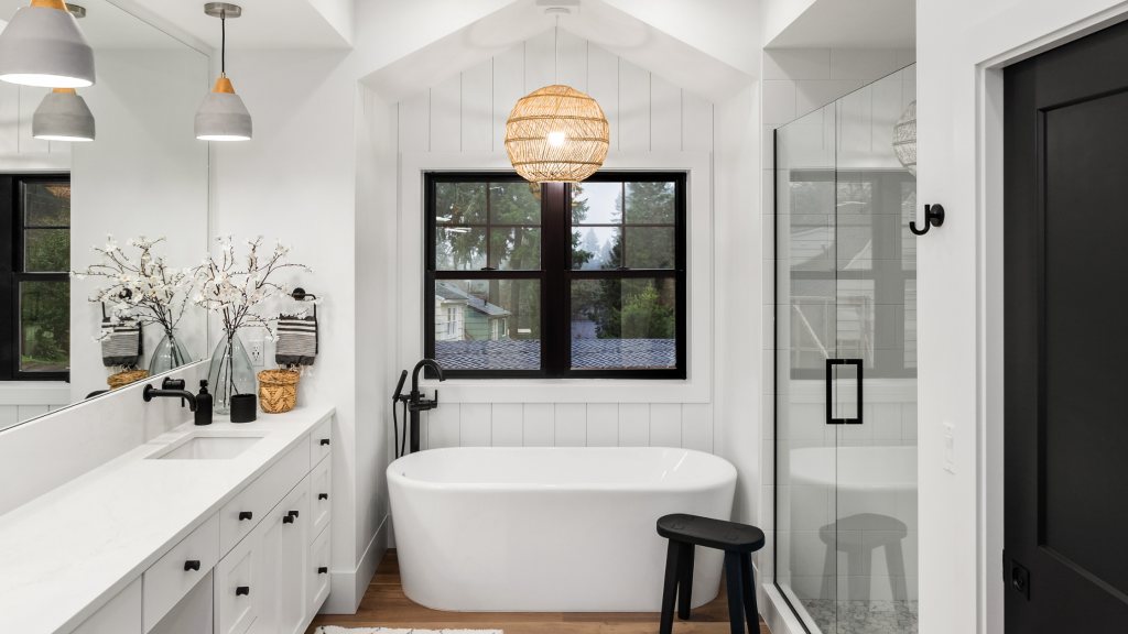 white bathroom with black fixtures featured and a standing tub in a small space